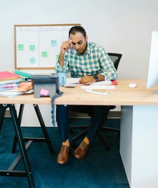 A focused man working at his desk with papers, showcasing a thoughtful work environment.